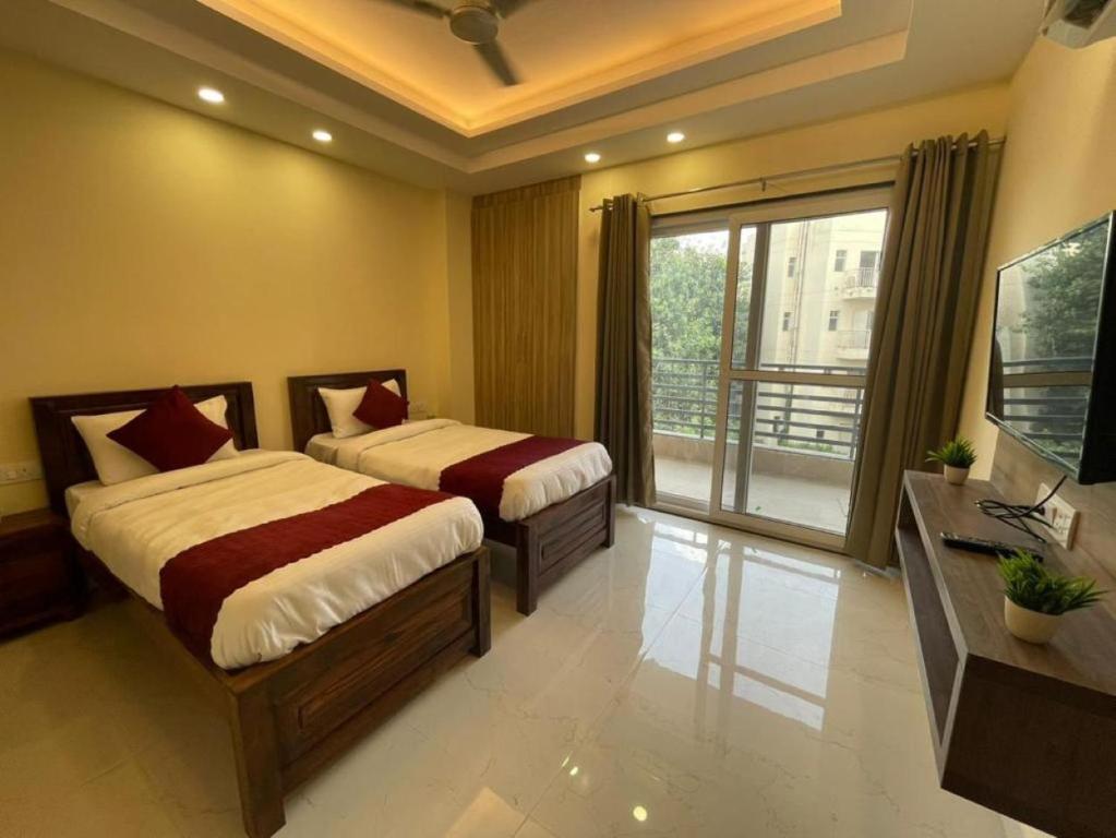 古尔冈MY STAY Service Appartment的一间卧室设有两张床和大窗户