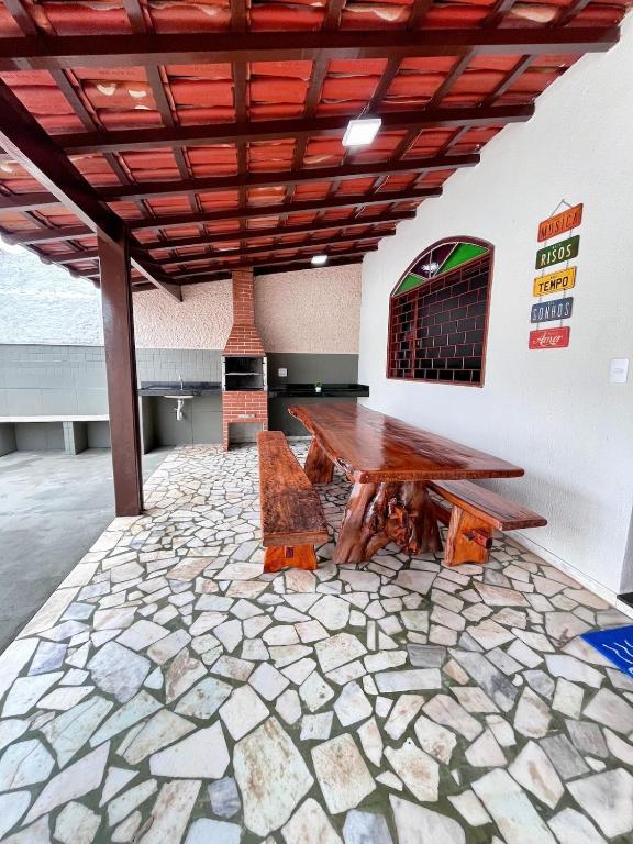 a patio with a wooden table and a stone floor at Casa na Praia do Morro Grande e Muito Arejada in Guarapari
