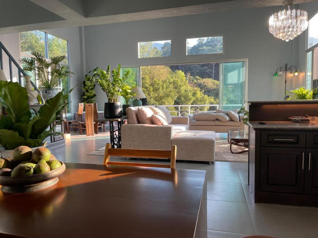 un salon avec un canapé et une table dans l'établissement Mon Jam Cottage, à Chiang Mai