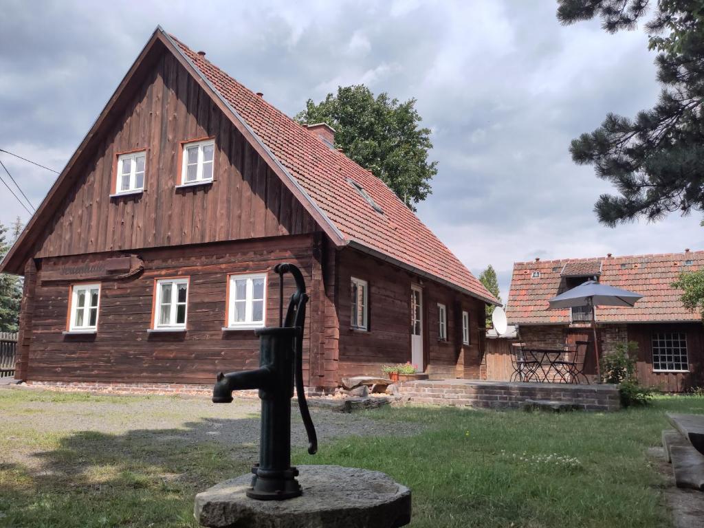 una grande casa in legno con un telescopio di fronte di Ferienhaus am Mühlteich a Rietschen