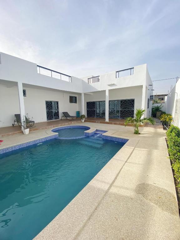 a house with a swimming pool in front of it at Camara's Home in Sali Nianiaral