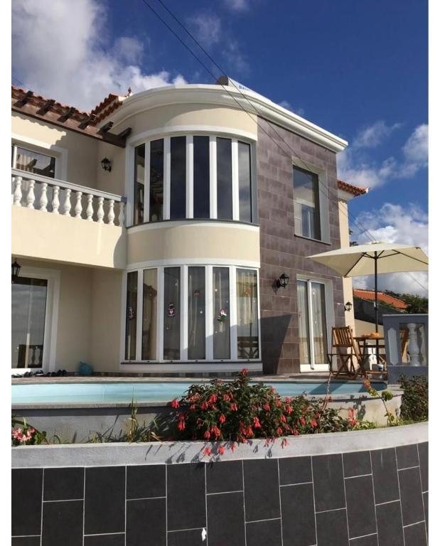 a house with a swimming pool in front of it at La terraza de Ponta do Sol -Suite 1 in Ponta do Sol