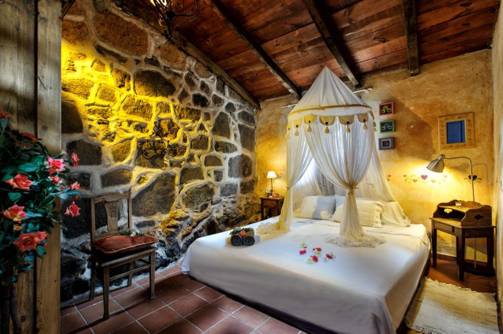 a bedroom with a bed and a stone wall at Casas ALBERTO TELEWORKING in San Miguel de Abona