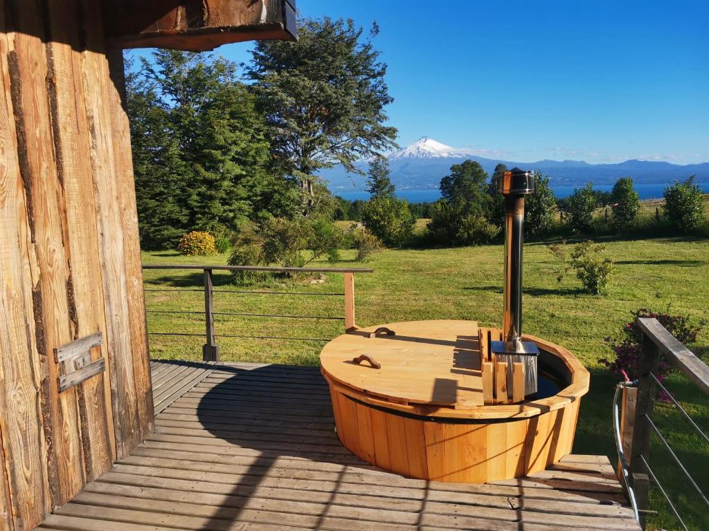 a wooden bath tub sitting on a wooden deck at Karibuni - Familiar Lodging & Private Spa in Villarrica