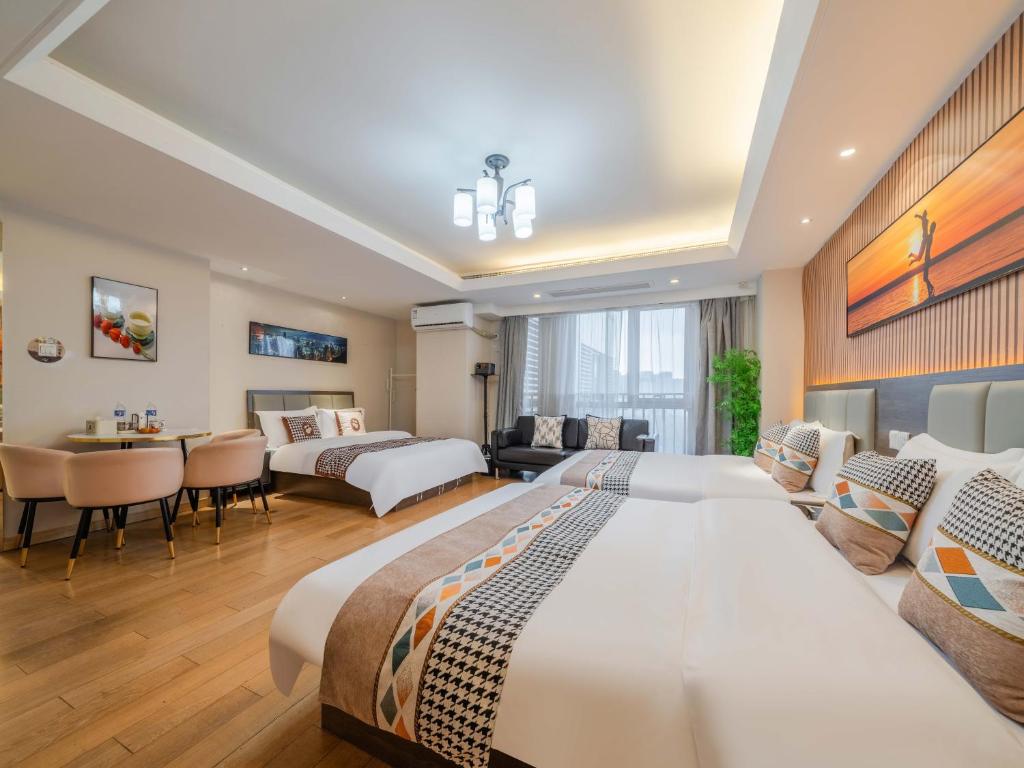 a bedroom with two beds and a living room at Shanghai Jubelle Boutique Apartment - Subway Lines 8-10-18 - Direct access to the Bund - Free fridge, washing machine, kitchen - Free luggage storage and package collection services in Shanghai