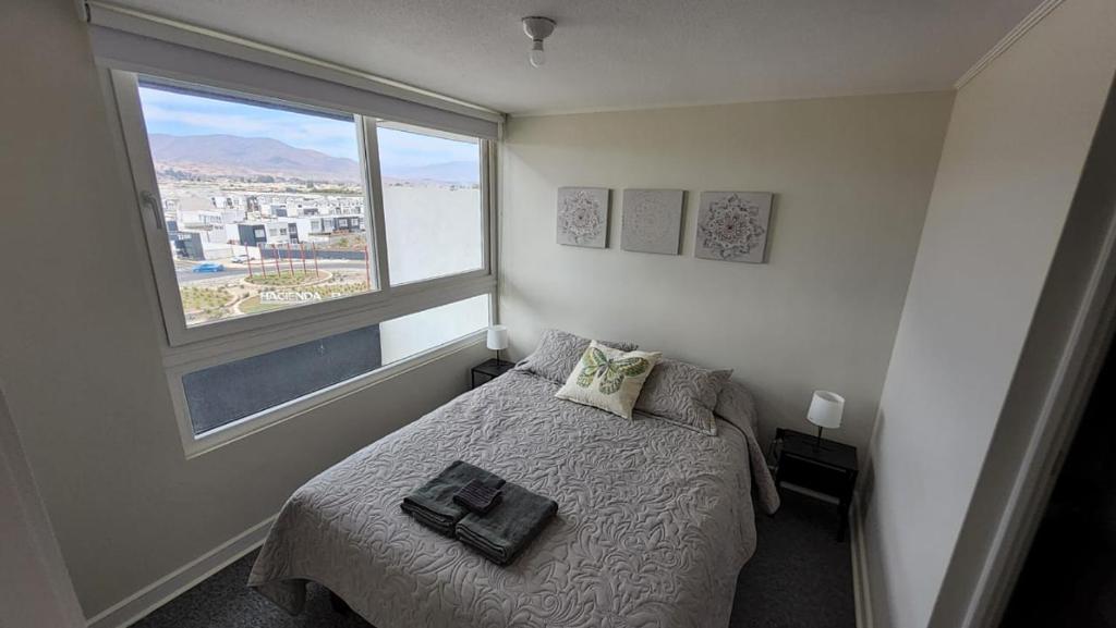 En eller flere senge i et værelse på Acogedor depto. centro La Serena