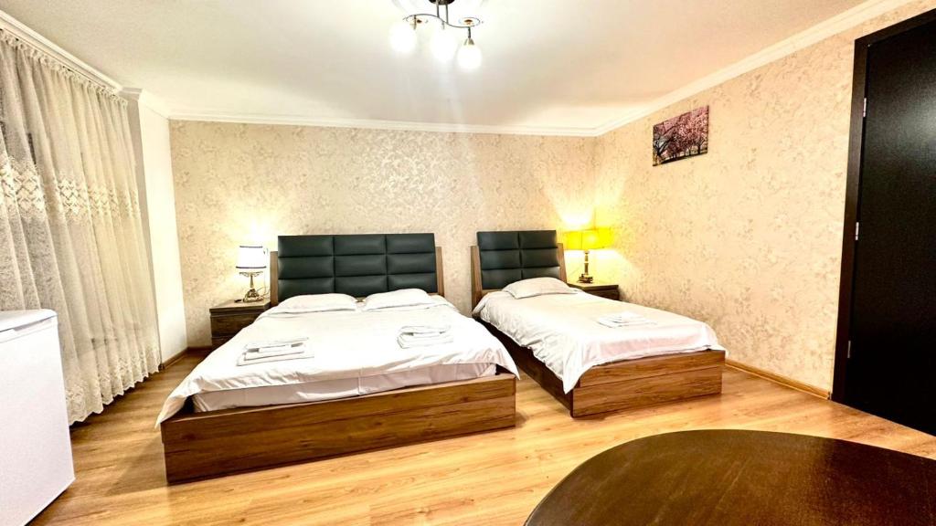 a bedroom with two beds and a table at Old city Apartment 1 in Tbilisi City
