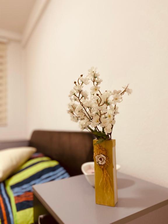 un jarrón lleno de flores blancas en una mesa en casa Felice, en Bitola