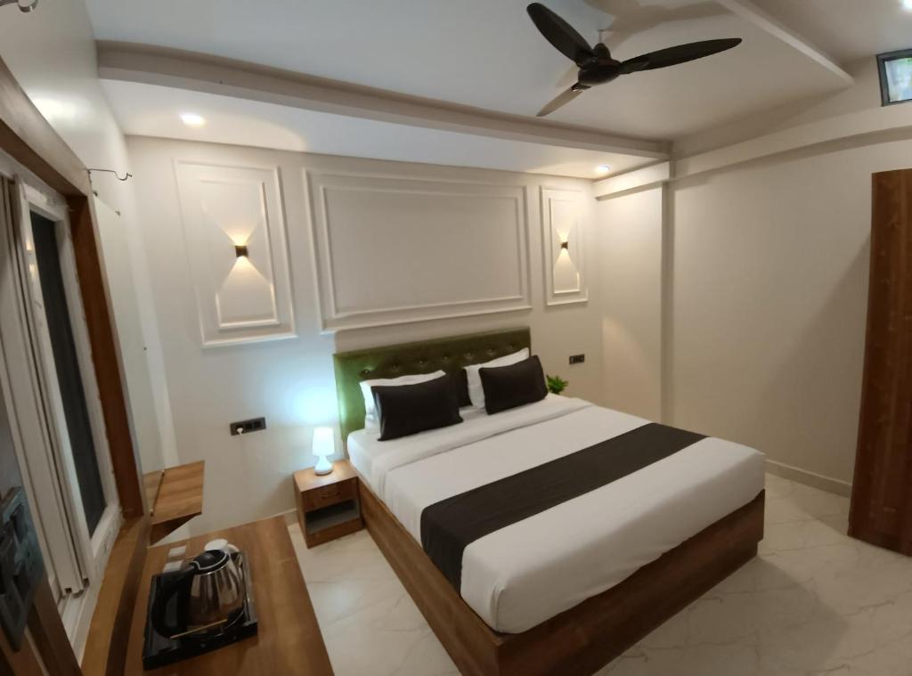 ジャバルプルにあるHotel Onyx Inn Zero Degreeのベッドと天井扇風機のある寝室