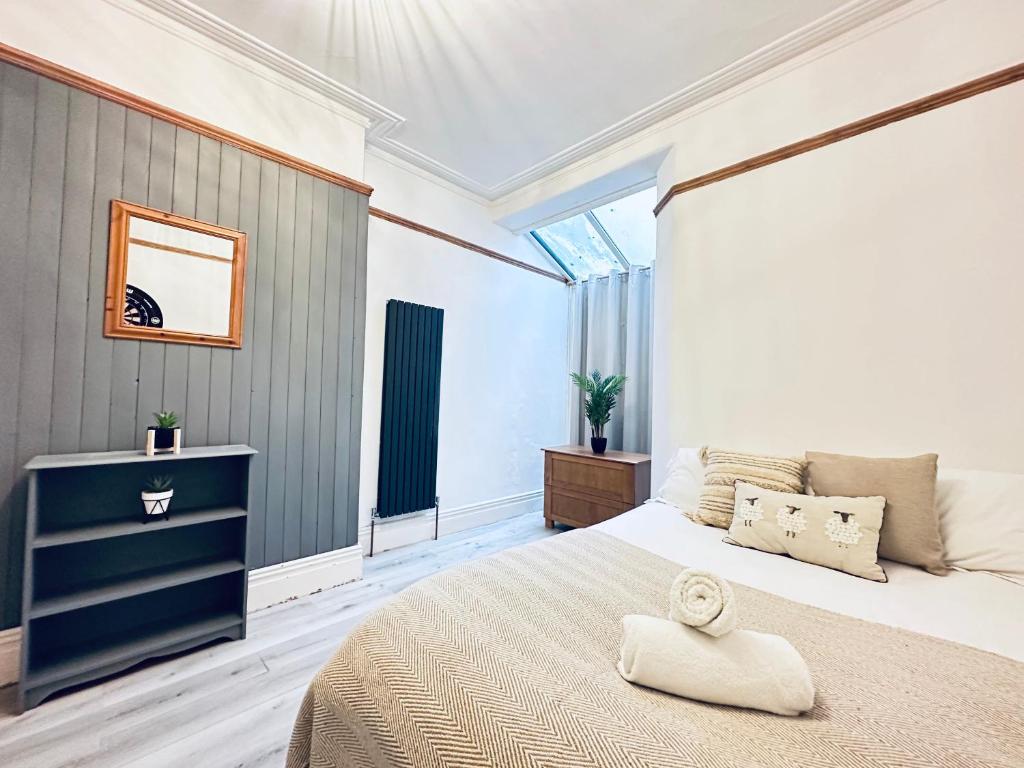 a bedroom with a bed with a towel on it at Lovey 6 Bed House Uplands Swansea - Perfect for Families and Contractors in Sketty