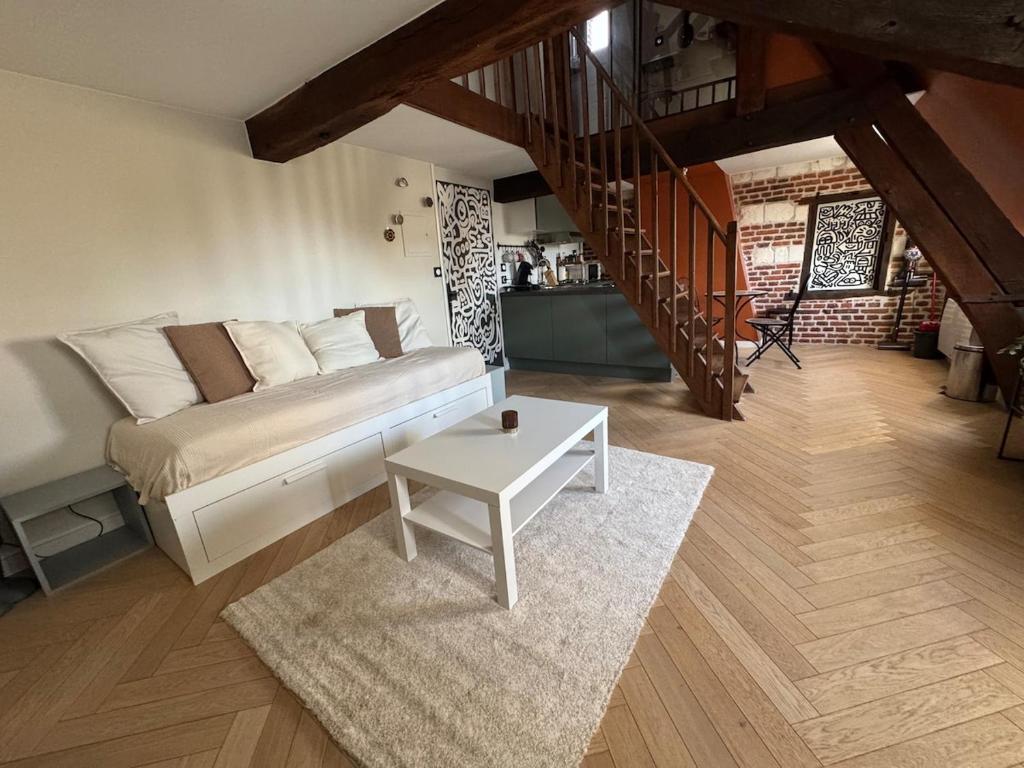 - une chambre avec un lit, une table et un escalier dans l'établissement Haring spot, à Arras