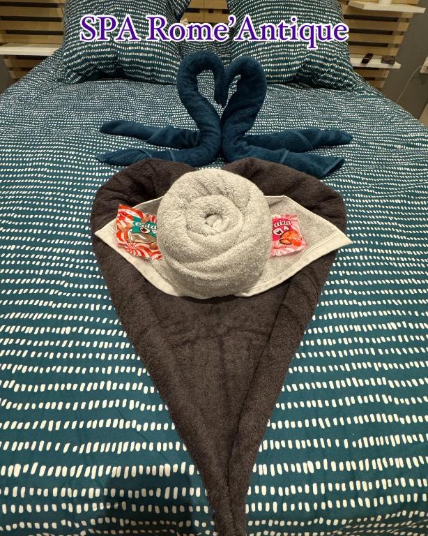 - une pile de serviettes sur le lit dans l'établissement SPA Rome Antique, à Courrières