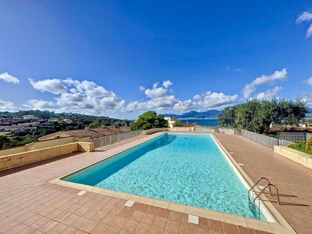 une grande piscine d'eau bleue sur une terrasse dans l'établissement T3 neuf Porticcio centre, à Porticcio