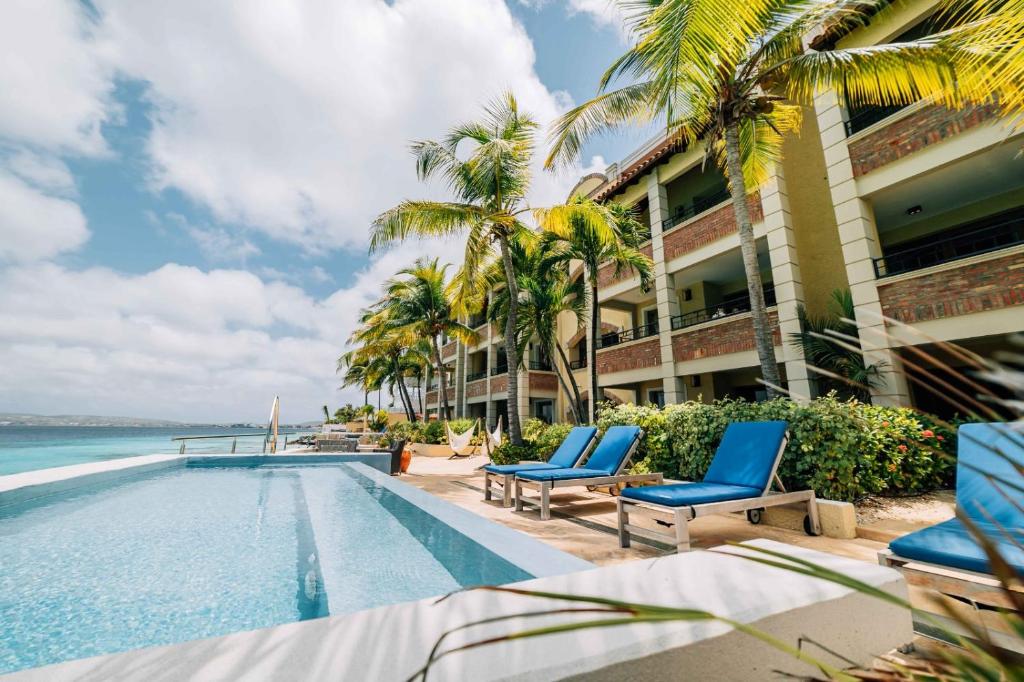 a resort with a swimming pool and palm trees at The Bellafonte - Luxury Oceanfront Hotel in Kralendijk
