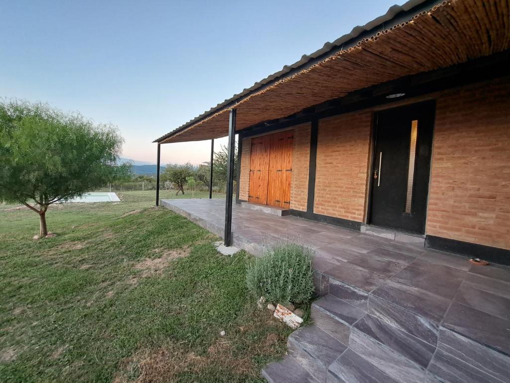 a brick building with a wooden door and a plant at Los Chivos in Villa Cura Brochero