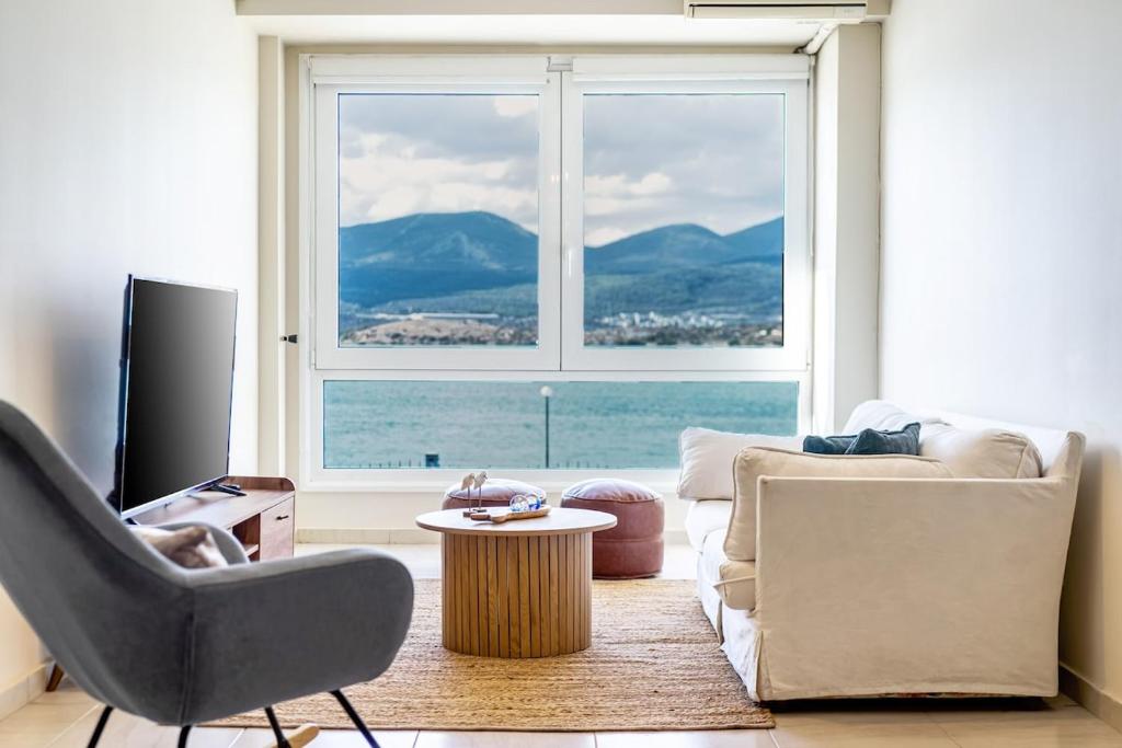 a living room with a large window and a couch at Chalkida Spacious Flat with amazing view! in Chalkida