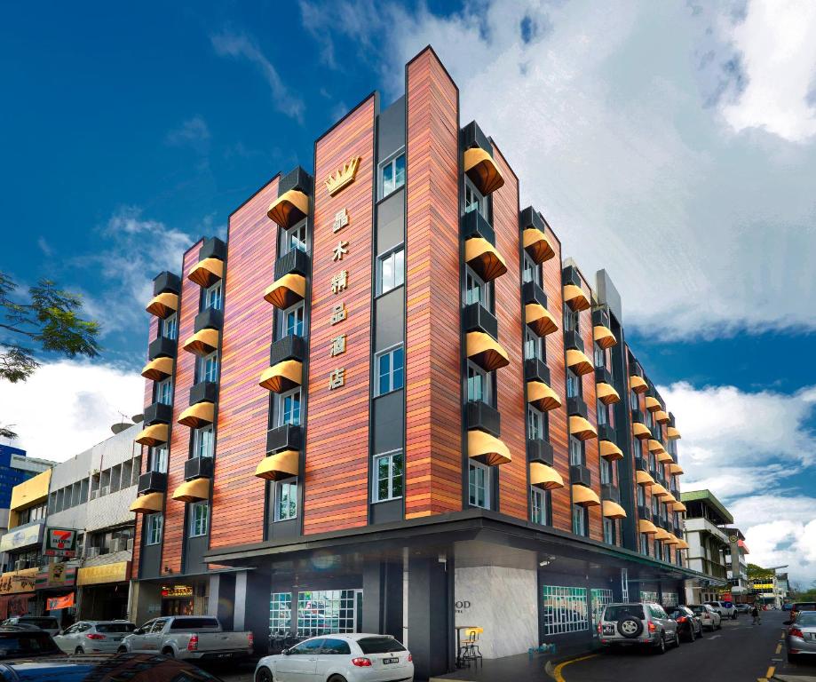 a tall building with cars parked in front of it at Kingwood Boutique Hotel in Miri