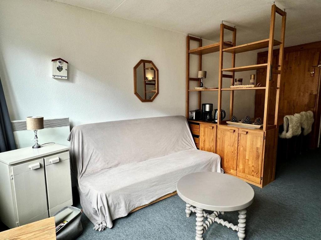 Cette chambre comprend un lit, une table et une étagère. dans l'établissement Résidence Le Tourmalet - maeva Home - Studio 4 personnes - Confort MAE-0401, à La Mongie