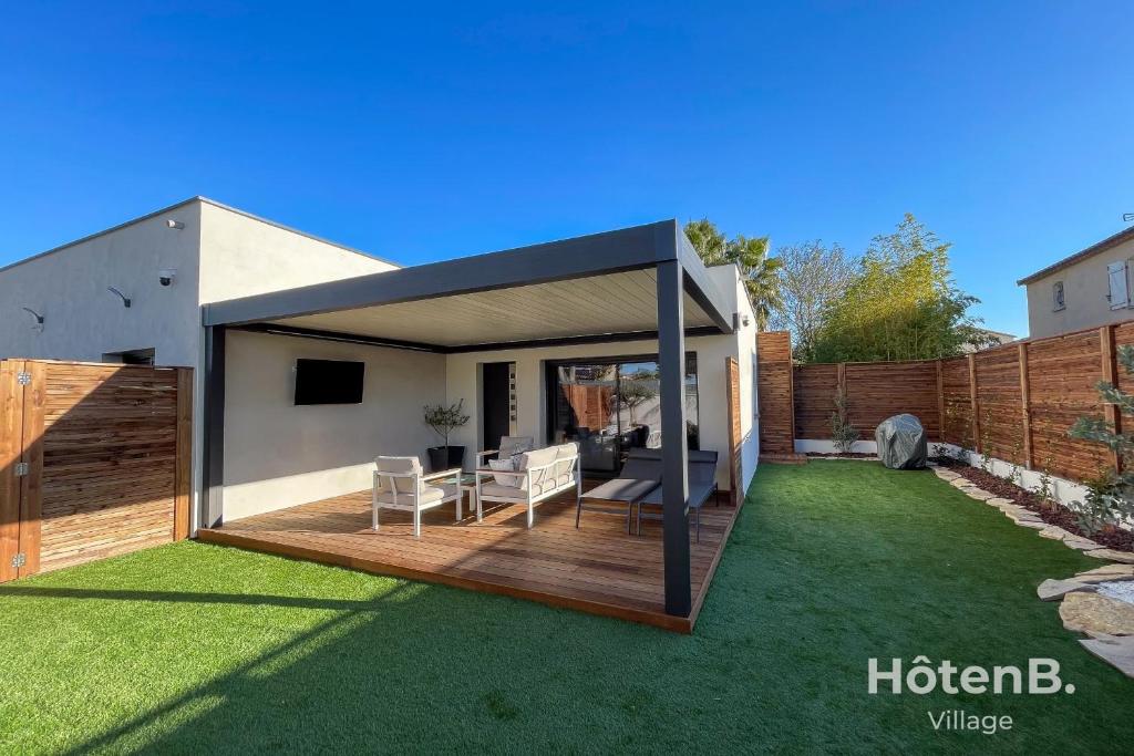 une arrière-cour avec une terrasse et une maison dans l'établissement L'Olivier - Private Spa and Garden, à Mèze