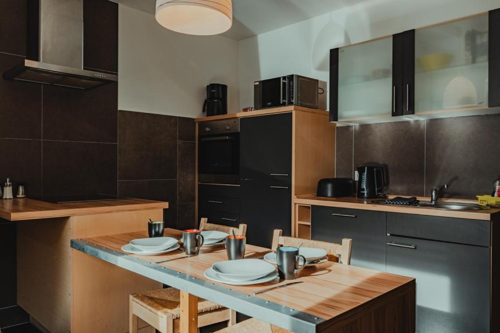 a kitchen with a wooden table with plates on it at HeinrichsOase 13 - Bielefeld Mitte in Bielefeld