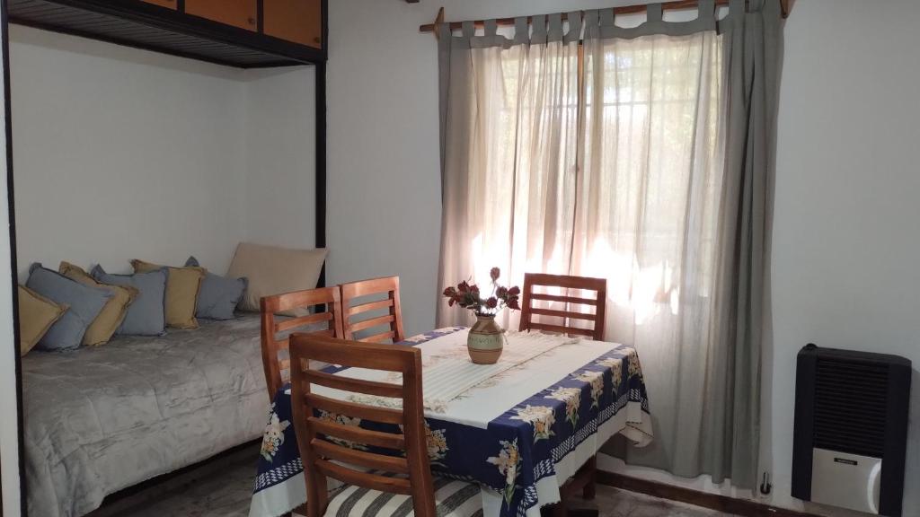a dining room table with two chairs and a bed at Alas De Cristal in Malargüe