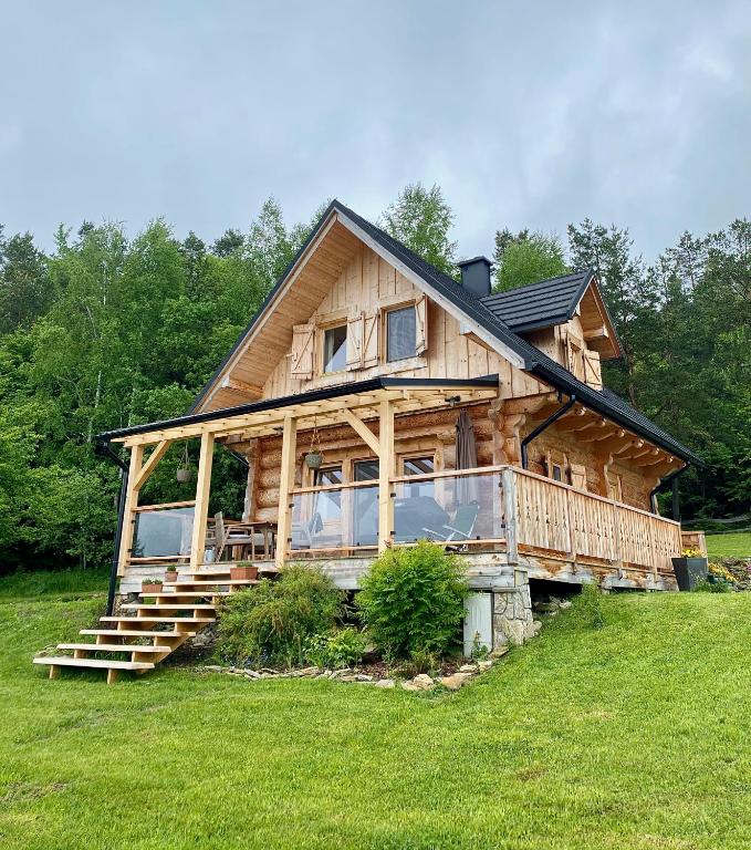 a large wooden house on a grass field at Jurkowa Wola in Jureczkowa