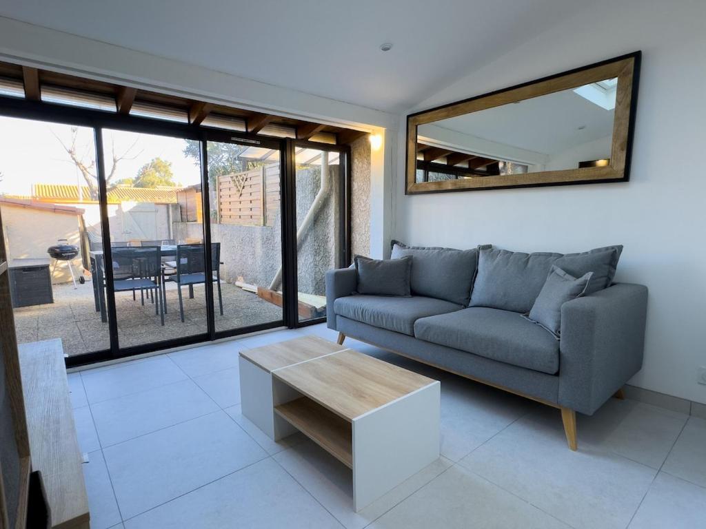 un salon avec un canapé et une table dans l'établissement Maison Cosy Plage à 10 min, Parking, Climatisation, Wi-Fi, à Saint Cyprien Plage