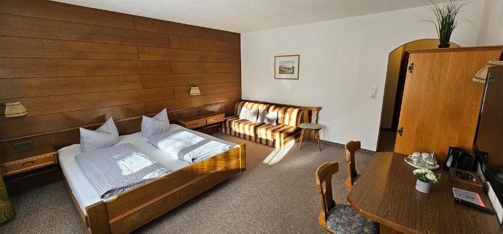 a bedroom with a bed and a couch at Pension Edi in Leutasch