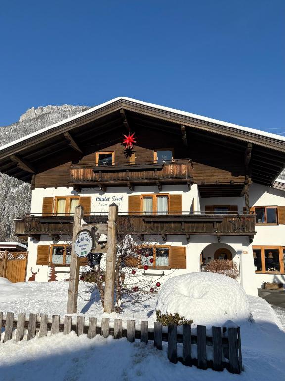a large building with snow on the ground in front of it at Chalet Tirol Waidring in Waidring