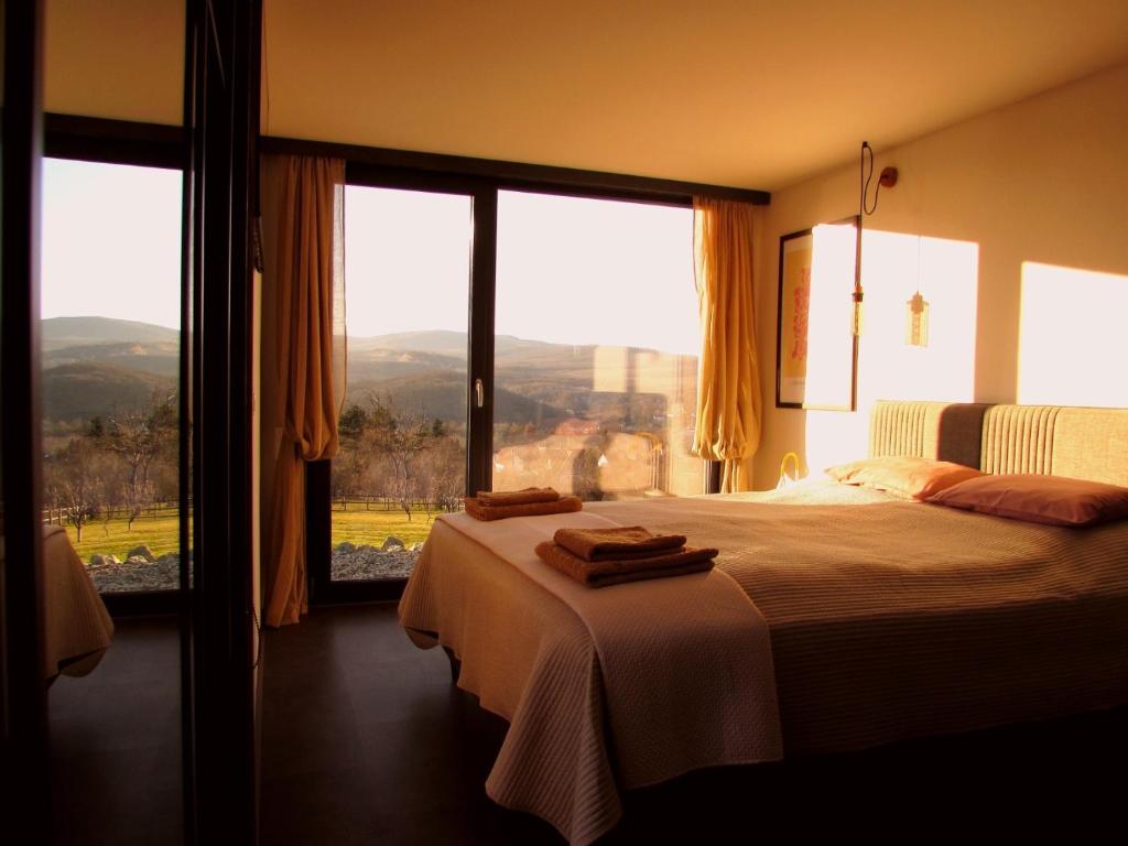 a bedroom with a bed and a large window at Casa Slarku - Luxury Container Houses in Miskolc
