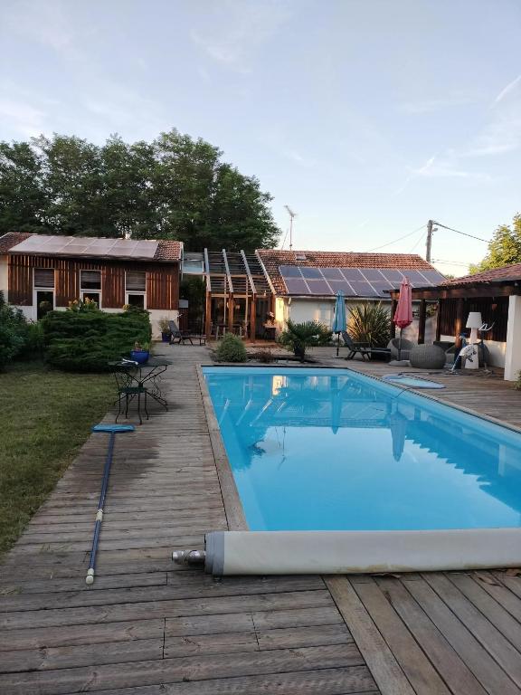 - une piscine sur une terrasse en bois à côté d'une maison dans l'établissement Villa charmante à Saint-Vincent-de-Paul avec piscine privée, à Saint-Vincent-de-Paul