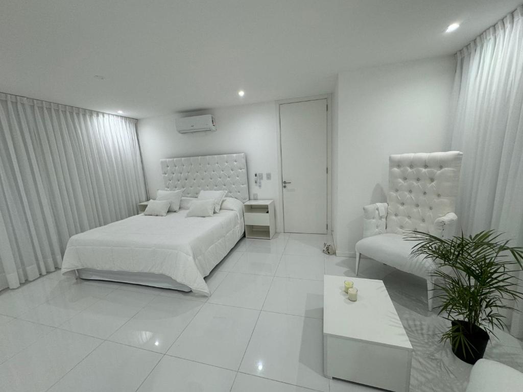 ein weißes Schlafzimmer mit 2 Betten und einem Sofa in der Unterkunft Serena Boutique Potrero Garay in Potrero de Garay