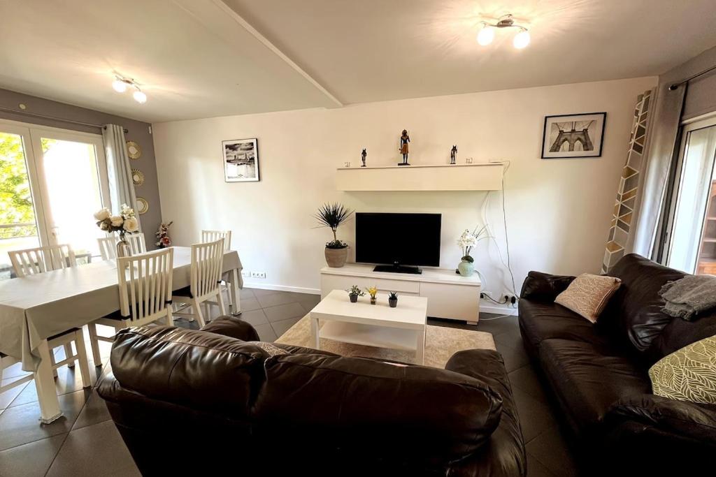 ein Wohnzimmer mit Sofa und Tisch in der Unterkunft Family home between Paris and Disneyland in Noisy-le-Grand