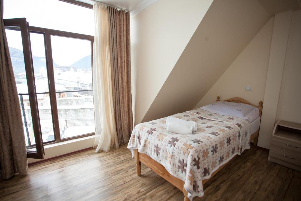 1 dormitorio con cama y ventana grande en Mestiatour Guest House, en Mestia