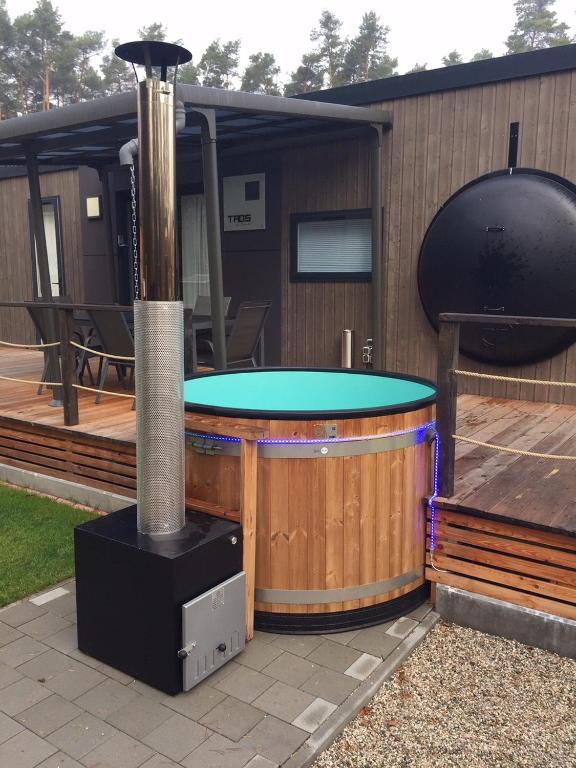 a hot tub on a deck next to a building at Mobilheim am Murner See - privater Badezuber & Grill in Wackersdorf