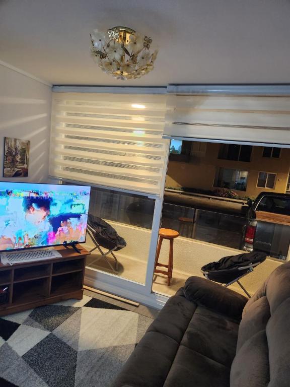 ein Wohnzimmer mit einer Couch und einem Laptop auf einem Tisch in der Unterkunft GiGIi in La Serena