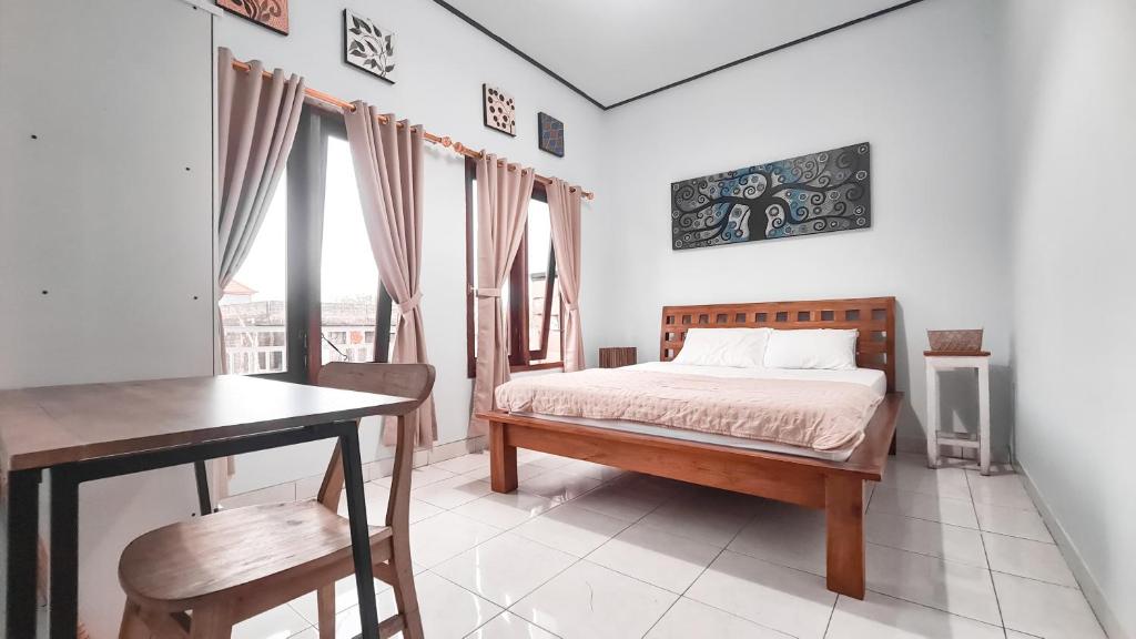 a bedroom with a bed and a table and chairs at Casa de Lami in Dalung