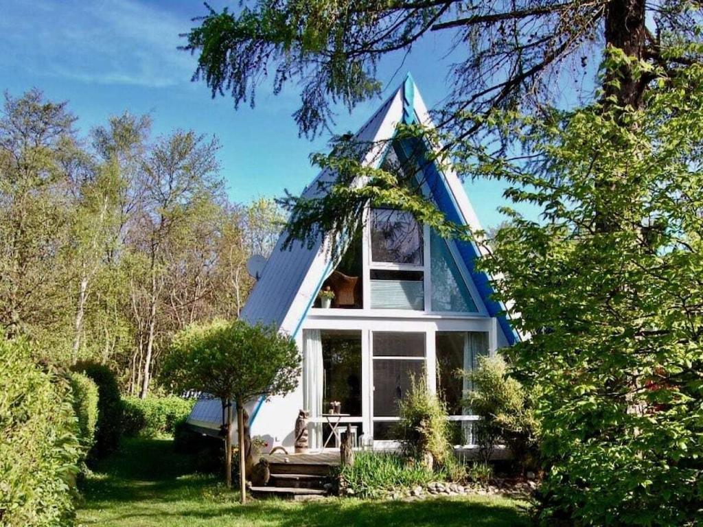 una casa azul y blanca con techo puntiagudo en Holiday home NurMeer, en Ahrenshoop
