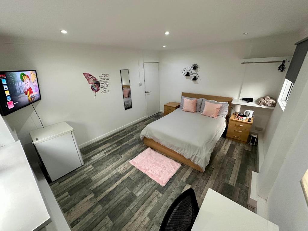 ein kleines Schlafzimmer mit einem Bett mit rosa Kissen in der Unterkunft 326 Your 2nd Home in London