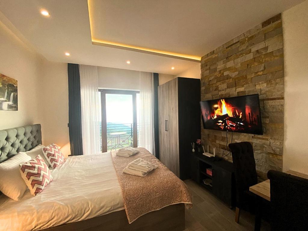 um quarto com uma cama e uma televisão numa parede de tijolos em Apartmani Srna Milmari em Kopaonik