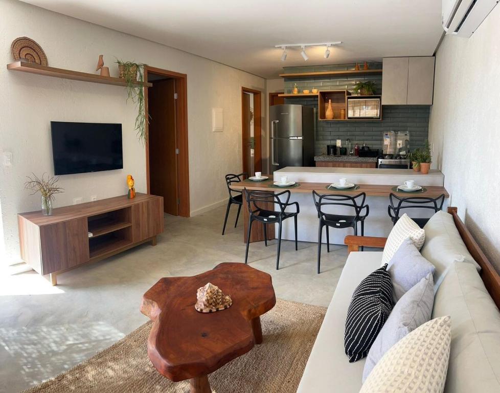 een woonkamer met een bank en een tafel en een keuken bij Casa Artur - Milagres in São Miguel dos Milagres