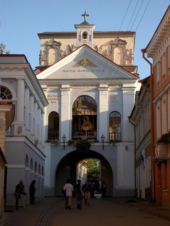 a large white building with an archway in a street at freeparking apartment in Vilnius