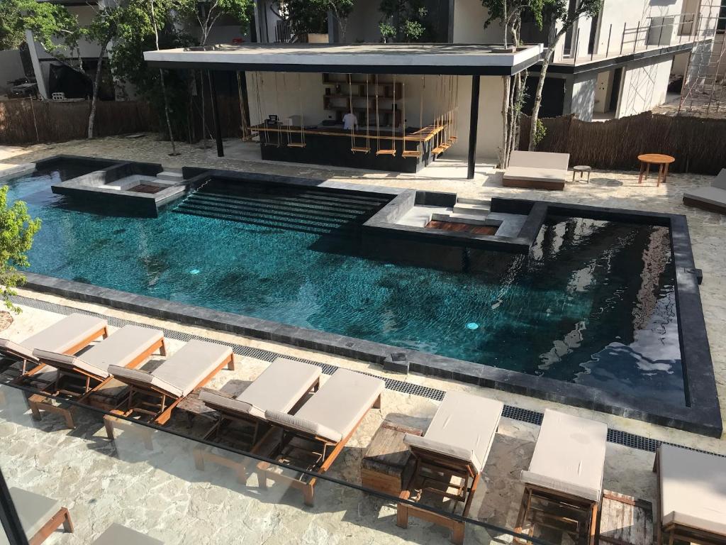 an overhead view of a swimming pool with lounge chairs at Nook Tulum in Tulum