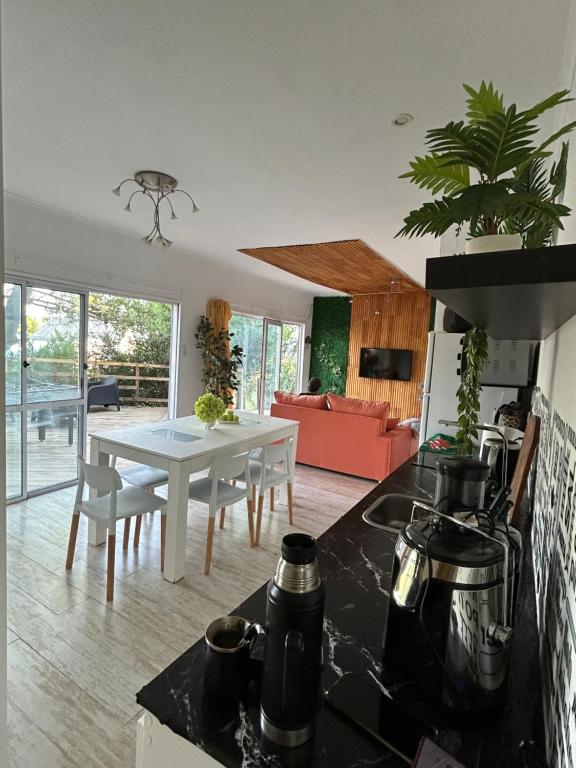 a kitchen and living room with a table and a dining room at Casa del Árbol in Monte Hermoso