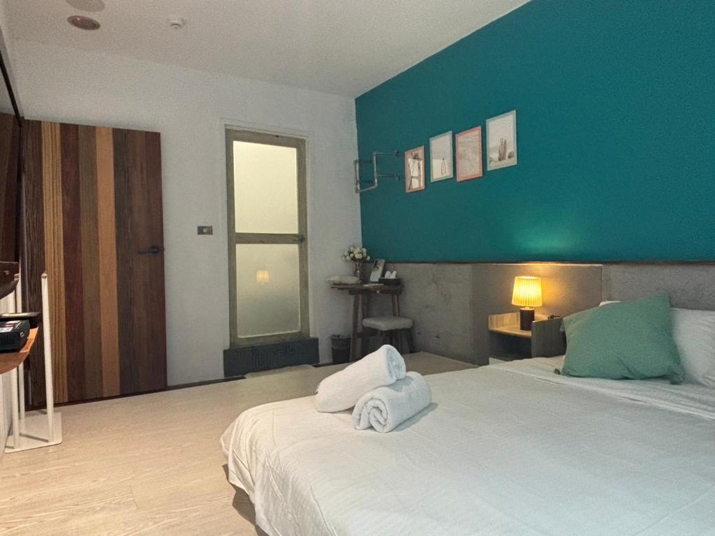 a bedroom with a large bed with a blue wall at Playful House in Kenting