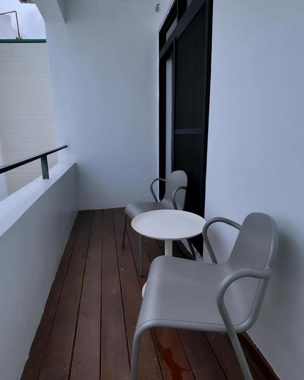 three chairs and a table in a room at Playful House in Kenting