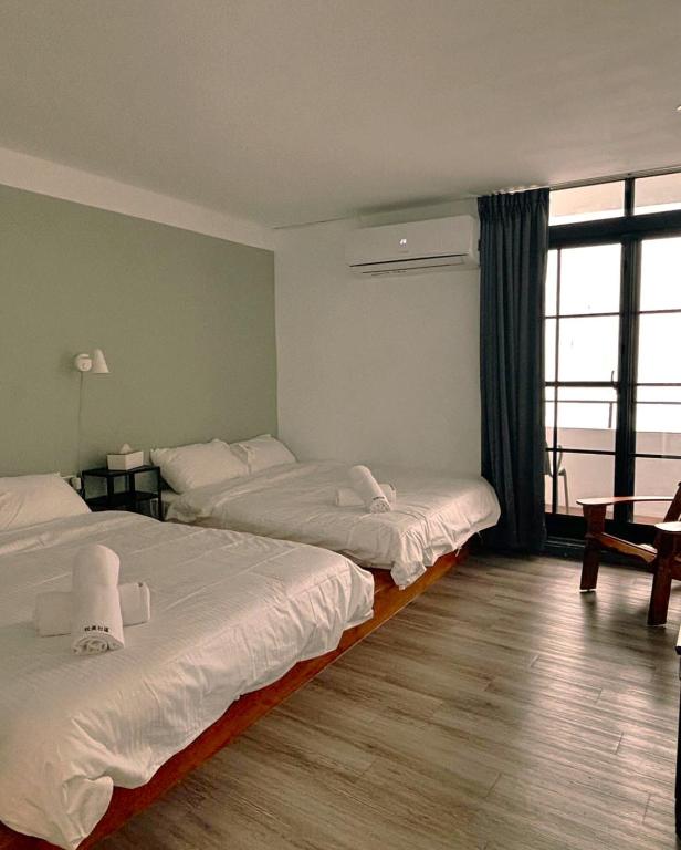 a hotel room with two beds and a window at Playful House in Kenting