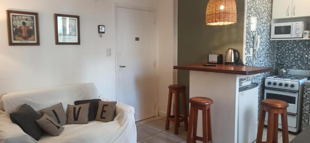 een woonkamer met een bank en een keuken bij Depto Gascón in Mar del Plata