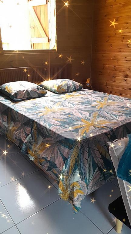 un letto con una trapunta colorata sopra in una stanza di LES HAUTS DE L'ANSE a Bouillante