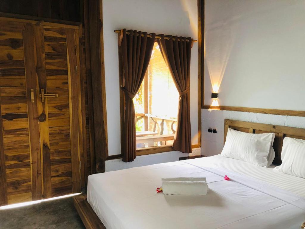 Postel nebo postele na pokoji v ubytování Umah Kayu 1-Menjangan homestay